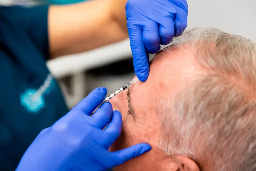 A Restoration MedSpa provider administers Botox injections in Greensboro into a patient's forehead.