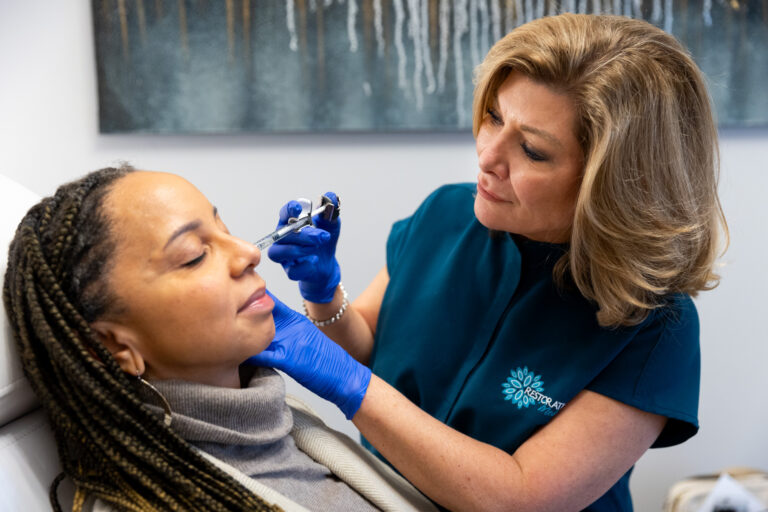 Side view of a licensed professional administering jawline filler in Winston-Salem for a female patient