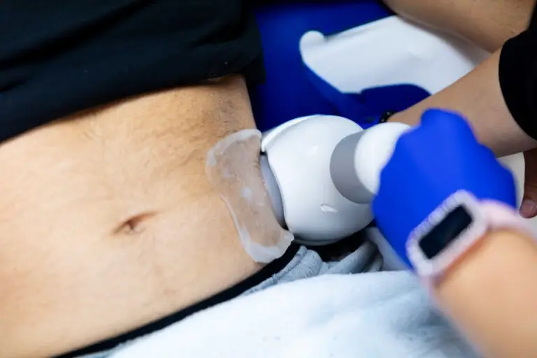 Close-up of a professional wearing gloves performing fat freezing in Winston-Salem on a patient's abdomen