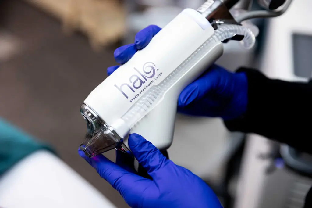 a medical professional wearing blue gloves prepares the HALO skin tightening device for a patient after using GLP-1 near High Point, NC