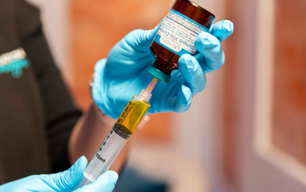 A close up of a Restoration MedSpa provider's hands as they prepare an nutrient blend for IV therapy. This complementary treatment for BHRT in Greensboro replenishes vitamins and nutrients to help clients feel at home in their bodies.
