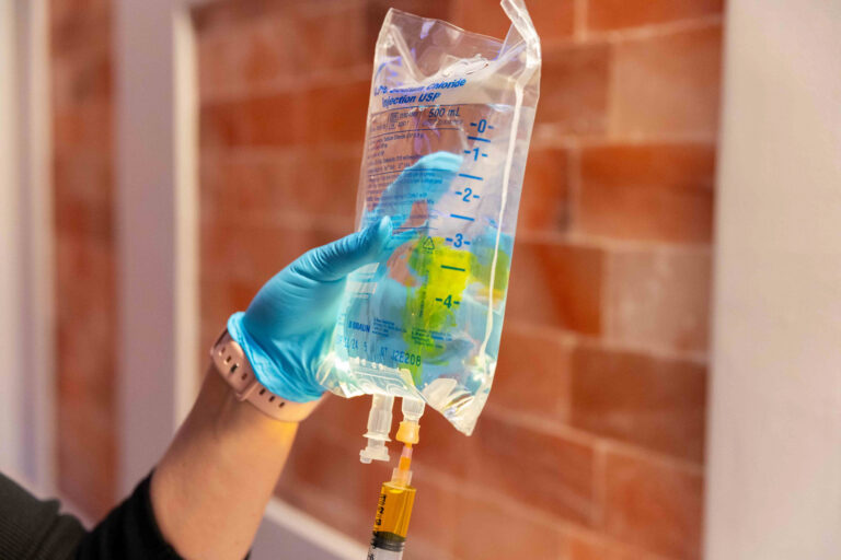 A nurse prepares a sterile fluid bag for IV hydration in Greensboro