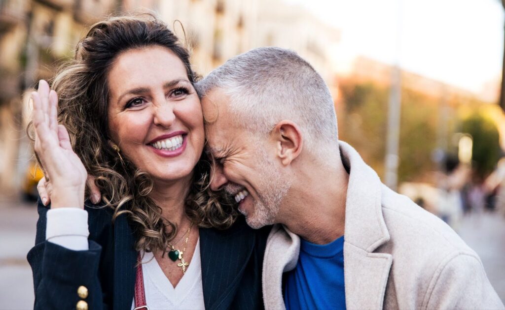 A mature couple laughs while enjoying a walk during fall after the man receives treatment for male enhancement in Greensboro