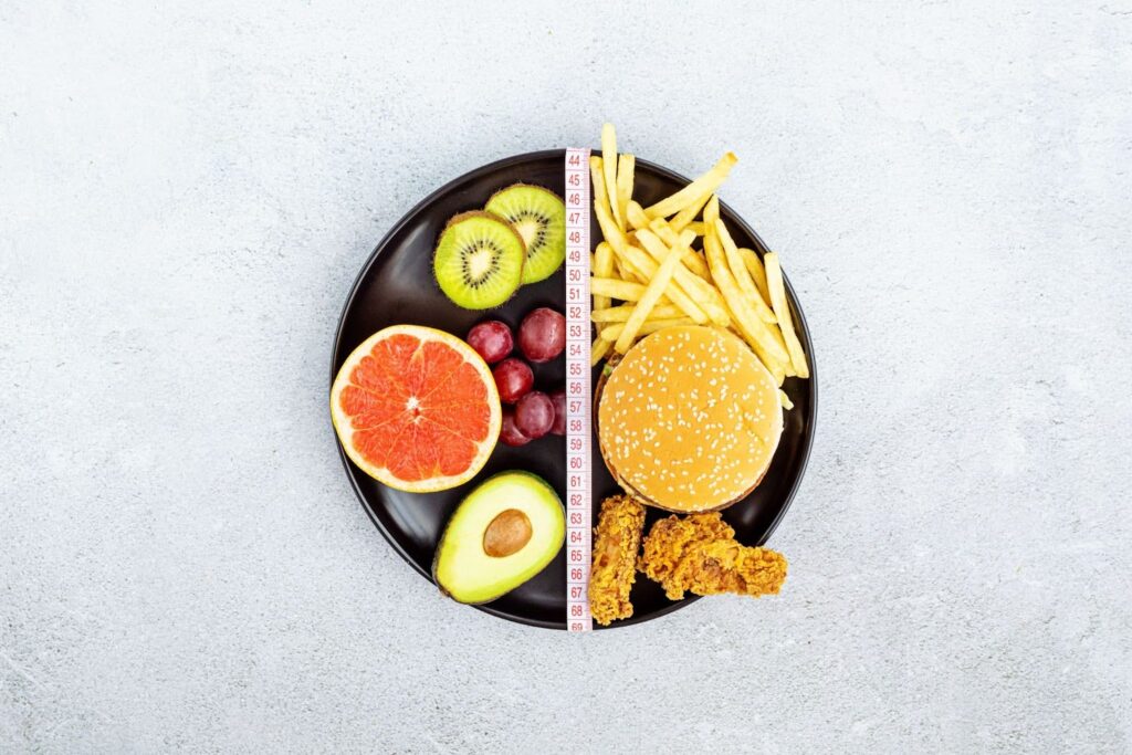 a plate shows half healthy foods and half less healthy foods to showcase why what you eat matters while using weight loss injections in High Point, NC