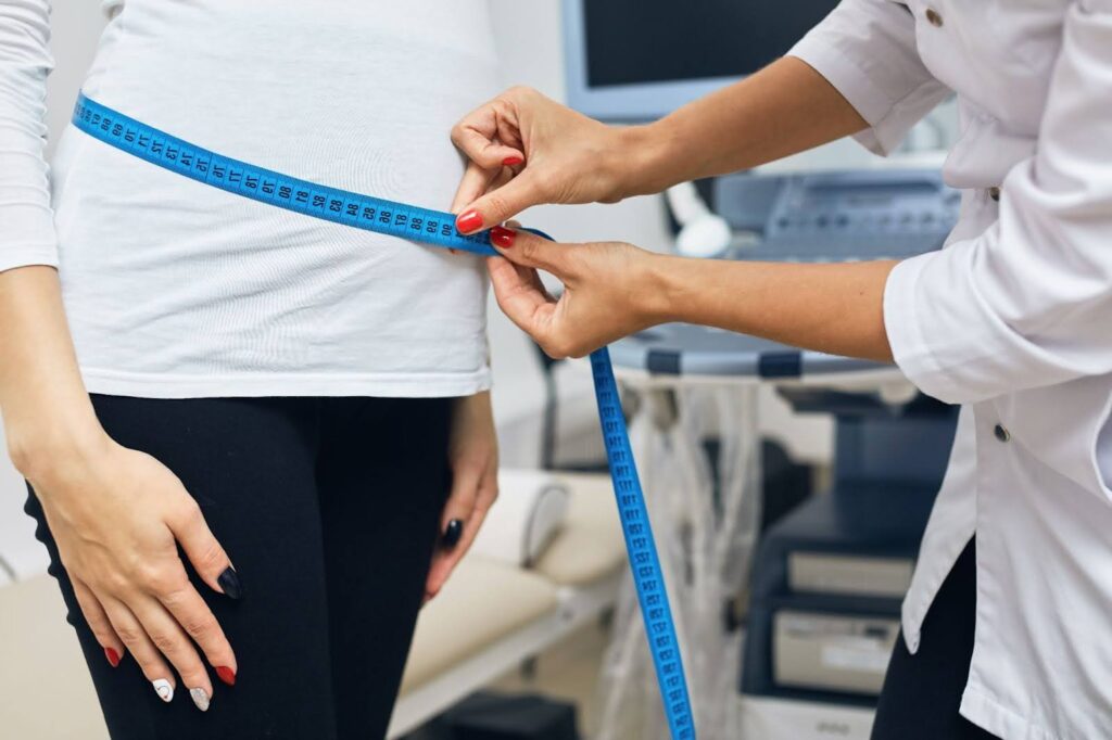 A doctor measures a patient's waist after they use weight loss injections in High Point, NC